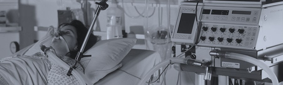 A person in a hospital bed connected to medical equipment
